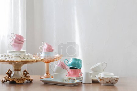 Téléchargez les photos : Plats pour servir le thé sur une table en bois sur fond blanc - en image libre de droit