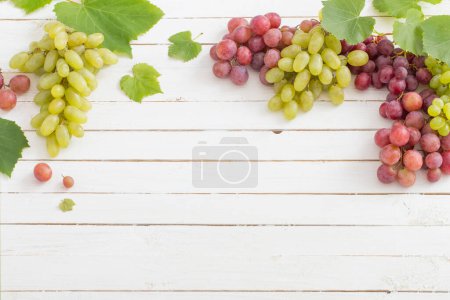 Photo for Pink and green grape on wooden background - Royalty Free Image