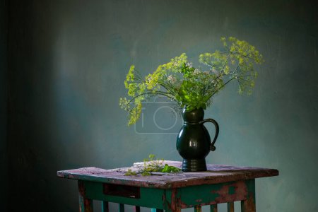 Téléchargez les photos : Bouquet vintage avec aneth dans une cruche en céramique sur une vieille table en bois sur fond sombre - en image libre de droit