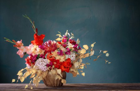 Téléchargez les photos : Bouquet d'automne avec des fleurs rouges et jaunes dans un vase en céramique sur fond sombre - en image libre de droit