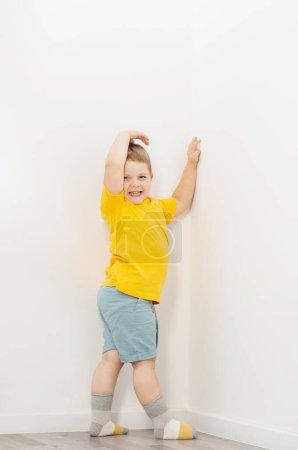 Foto de Niño con sobrepeso en escamas en casa - Imagen libre de derechos