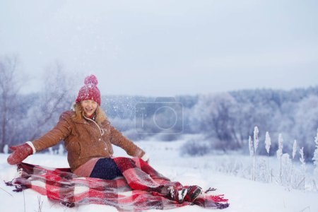 Foto de Hermosa adolescente chica en cuadros en la nieve - Imagen libre de derechos