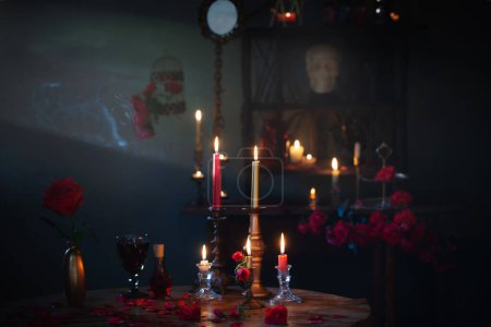 Zaubertrank mit roten Rosen und brennenden Kerzen im dunklen Raum