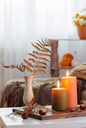 Téléchargez les photos : Bougies allumées avec décor d'automne sur table blanche à la maison - en image libre de droit