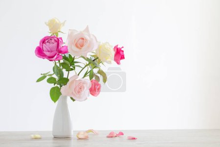 Téléchargez les photos : Roses roses et blanches dans un vase en céramique blanche sur fond blanc - en image libre de droit