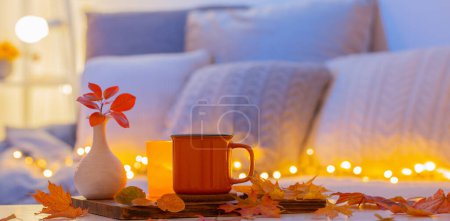 Photo for Cup of tea and  autumnal leaves in cozy interior - Royalty Free Image