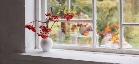 Photo for Rowan berries in white vase on old white windowsill - Royalty Free Image