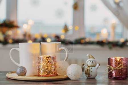 Foto de Dos tazas blancas con decoraciones de Navidad en la ventana de fondo - Imagen libre de derechos