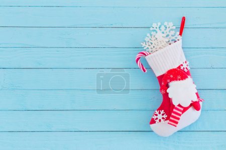 Téléchargez les photos : Bas de Noël avec des cadeaux suspendus sur fond bleu en bois - en image libre de droit