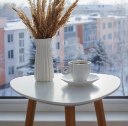 Téléchargez les photos : Tasse de café sur table blanche par fenêtre en hiver - en image libre de droit