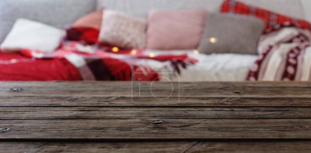 Photo for Old wooden table on background sofa with pillows and plaids - Royalty Free Image