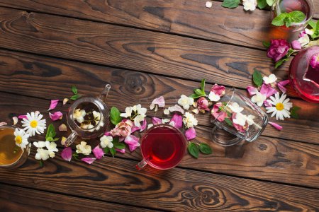 Photo for Various teas with herbs and flowers on a dark wooden table, top view - Royalty Free Image