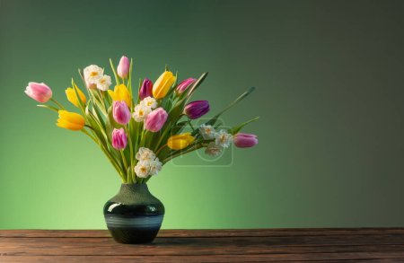 Foto de Flores de primavera en jarrón de cerámica sobre mesa de madera - Imagen libre de derechos