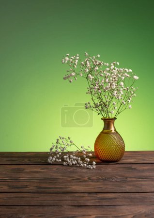 Photo for Gypsophila flowers in vase on green background - Royalty Free Image