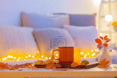 Photo for Cup of tea and  autumnal leaves in cozy interior - Royalty Free Image