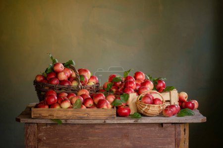Téléchargez les photos : Pommes rouges sur une vieille table en bois sur fond vert mur - en image libre de droit