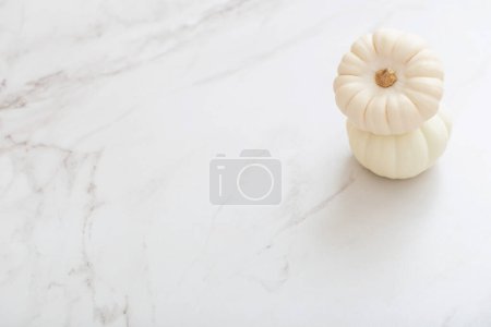 Téléchargez les photos : Citrouilles blanches sur fond de marbre blanc - en image libre de droit