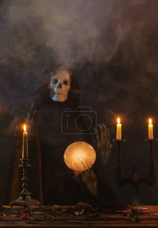 Photo for Death predicts the future with  crystal ball in dark room - Royalty Free Image