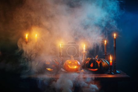 Foto de Calabazas de Halloween con velas encendidas sobre fondo oscuro - Imagen libre de derechos