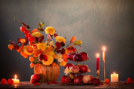 Beautiful autumnal  bouquet on wooden table on dark wall