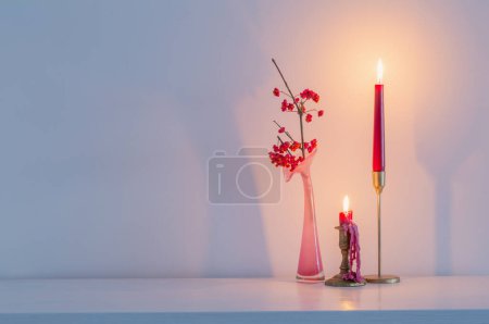 Foto de Decoración de Navidad rosa con velas encendidas en el interior blanco - Imagen libre de derechos