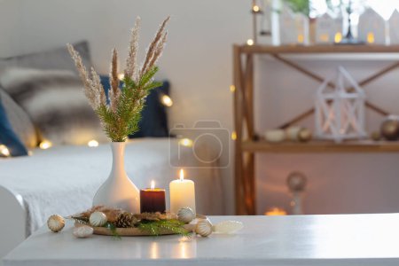 Téléchargez les photos : Bougies allumées avec décor de Noël dans un intérieur confortable blanc - en image libre de droit