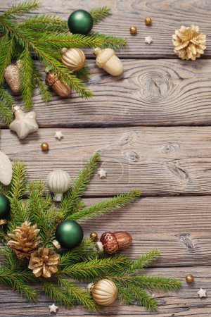 Foto de Juguetes de Navidad dorados con ramas de abeto sobre fondo de madera oscura - Imagen libre de derechos