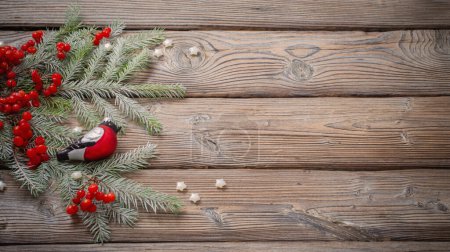 Foto de Fondo de Navidad con bayas rojas, pinzón de vidrio y ramas de abeto en la mesa de madera oscura - Imagen libre de derechos