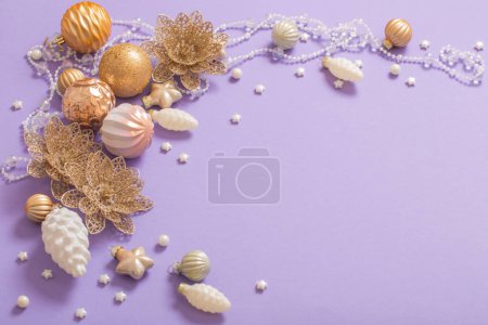 Foto de Juguetes de Navidad dorados sobre fondo púrpura - Imagen libre de derechos