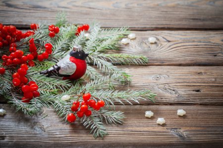 Foto de Fondo de Navidad con bayas rojas, pinzón de vidrio y ramas de abeto en la mesa de madera oscura - Imagen libre de derechos