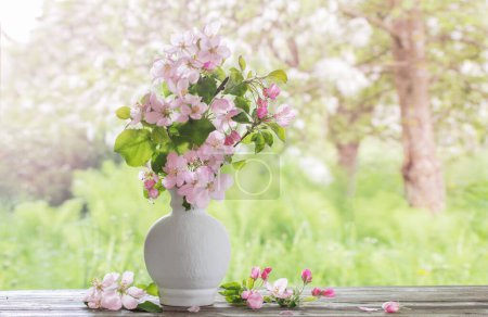 Photo for Apple flowers in white vase on background spring garden - Royalty Free Image