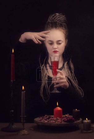 Foto de Bruja joven con rastas sobre fondo oscuro - Imagen libre de derechos