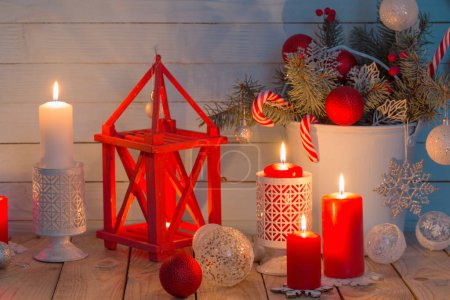 Foto de Decoraciones navideñas con velas encendidas sobre fondo azul de madera - Imagen libre de derechos