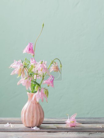 Photo for Pink flowers in pink vase  on background green wall - Royalty Free Image