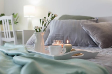 Téléchargez les photos : Tasse de café sur plateau en bois au lit avec des fleurs et des bougies - en image libre de droit