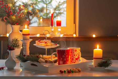 Téléchargez les photos : Décor de Noël et tasses rouges avec boisson chaude sur la cuisine - en image libre de droit