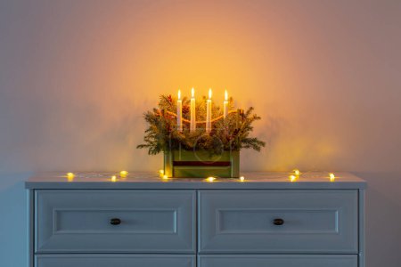 Photo for Advent decoration with fir branches and four burning candles in wooden basket on white background - Royalty Free Image
