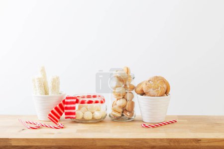 Photo for Christmas candies and cookies  in jars on wooden shelf on white background - Royalty Free Image