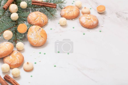 Photo for Candies and cookies with christmas tree branches on white marble background - Royalty Free Image