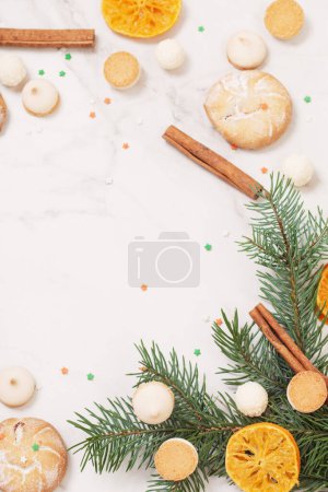 Téléchargez les photos : Bonbons et biscuits avec branches d'arbre de Noël sur fond de marbre blanc - en image libre de droit