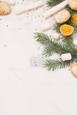 Photo for Candies and cookies with christmas tree branches on white marble background - Royalty Free Image