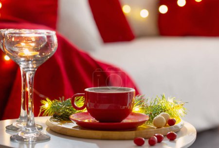 Foto de Taza de bebida caliente con decoraciones navideñas en colores blanco y rojo en casa - Imagen libre de derechos