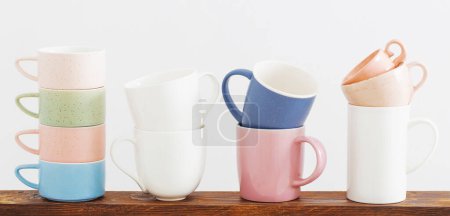 Photo for Colorful cups on  wooden shelf on  white background - Royalty Free Image