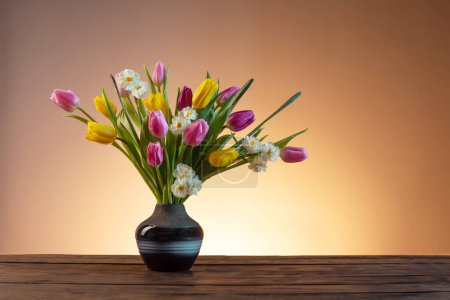 Téléchargez les photos : Fleurs de printemps en vase en céramique bleue sur table en bois - en image libre de droit