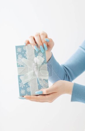 Foto de Mano femenina con caja de regalo de Navidad sobre fondo blanco - Imagen libre de derechos