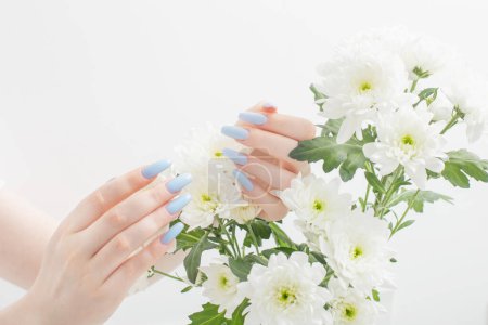Téléchargez les photos : Mains féminines avec belle manucure et fleurs de chrysanthème - en image libre de droit