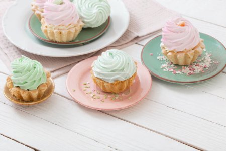 Téléchargez les photos : Cupcakes sur assiettes sur fond bois blanc - en image libre de droit