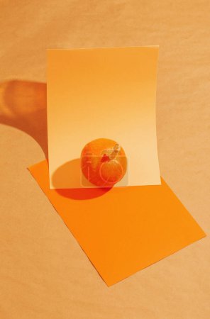 Téléchargez les photos : Petite citrouille orange sur des feuilles de papier orange - en image libre de droit