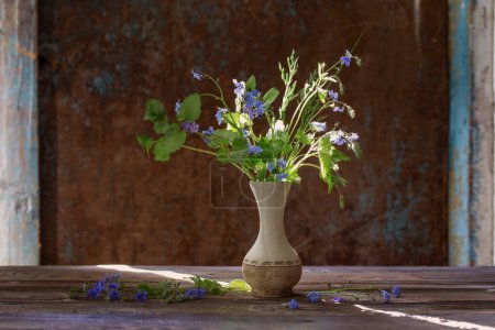 Téléchargez les photos : Fleurs sauvages dans un vase sur fond vieux mur - en image libre de droit