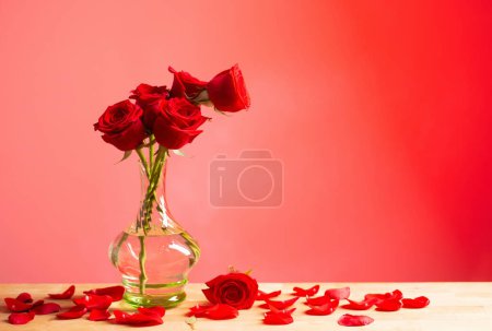 Photo for Red roses in glass vase on red background - Royalty Free Image